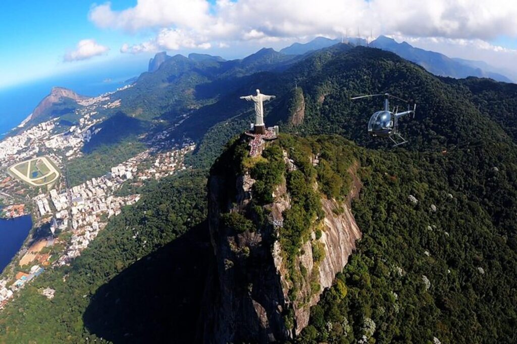 Helicóptero realizando voo panorâmico sobre o Cristo Redentor, Pão de Açúcar e as praias de Copacabana e Ipanema no Rio de Janeiro.